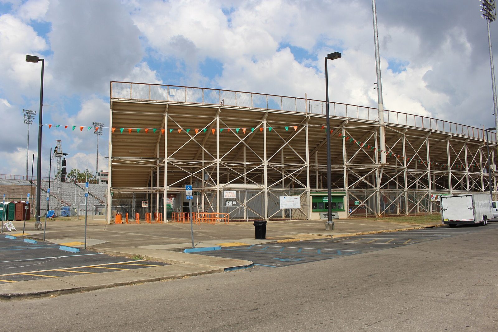 Stadium exterior with bleachers, parking spaces and small trailer, Bragg Memorial Stadium