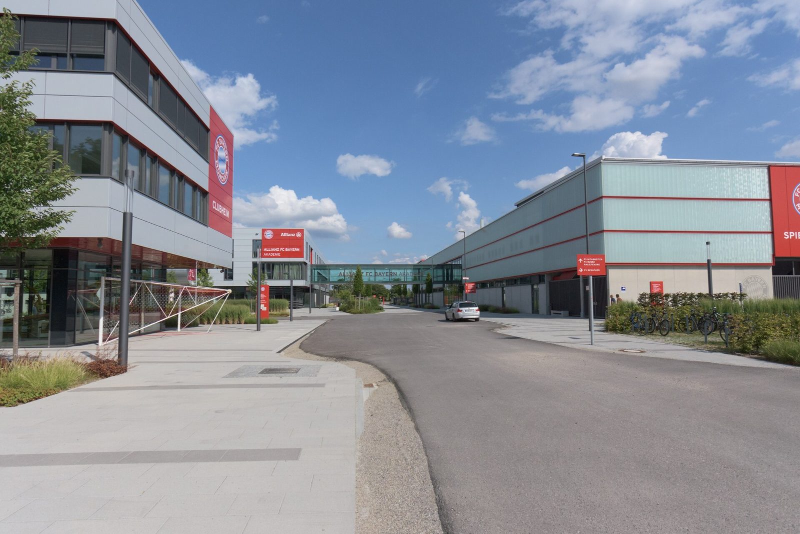 Wide view of academy buildings and empty access road, FC Bayern Campus