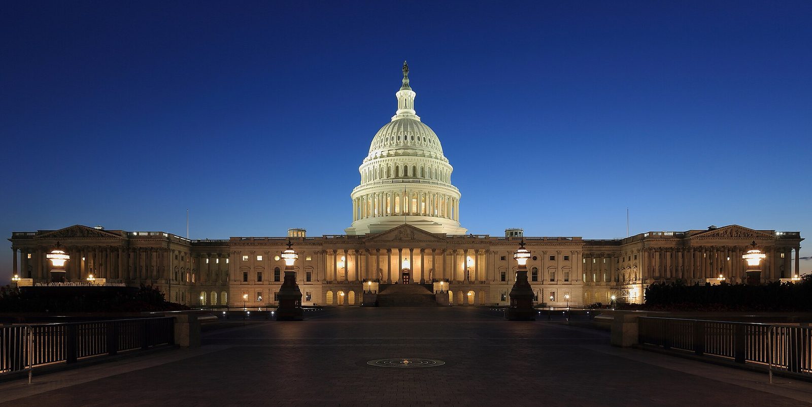 Illuminated US Capitol building at dusk, empty foreground