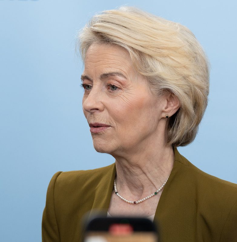 Profile portrait of a middle-aged woman against a pale blue background