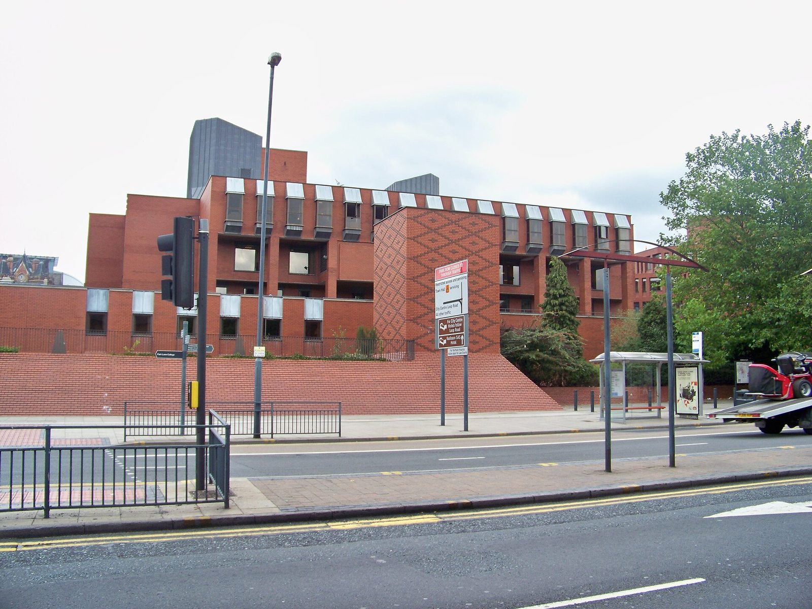 Red-brick court building, traffic lights and bus shelter in foreground, Leeds