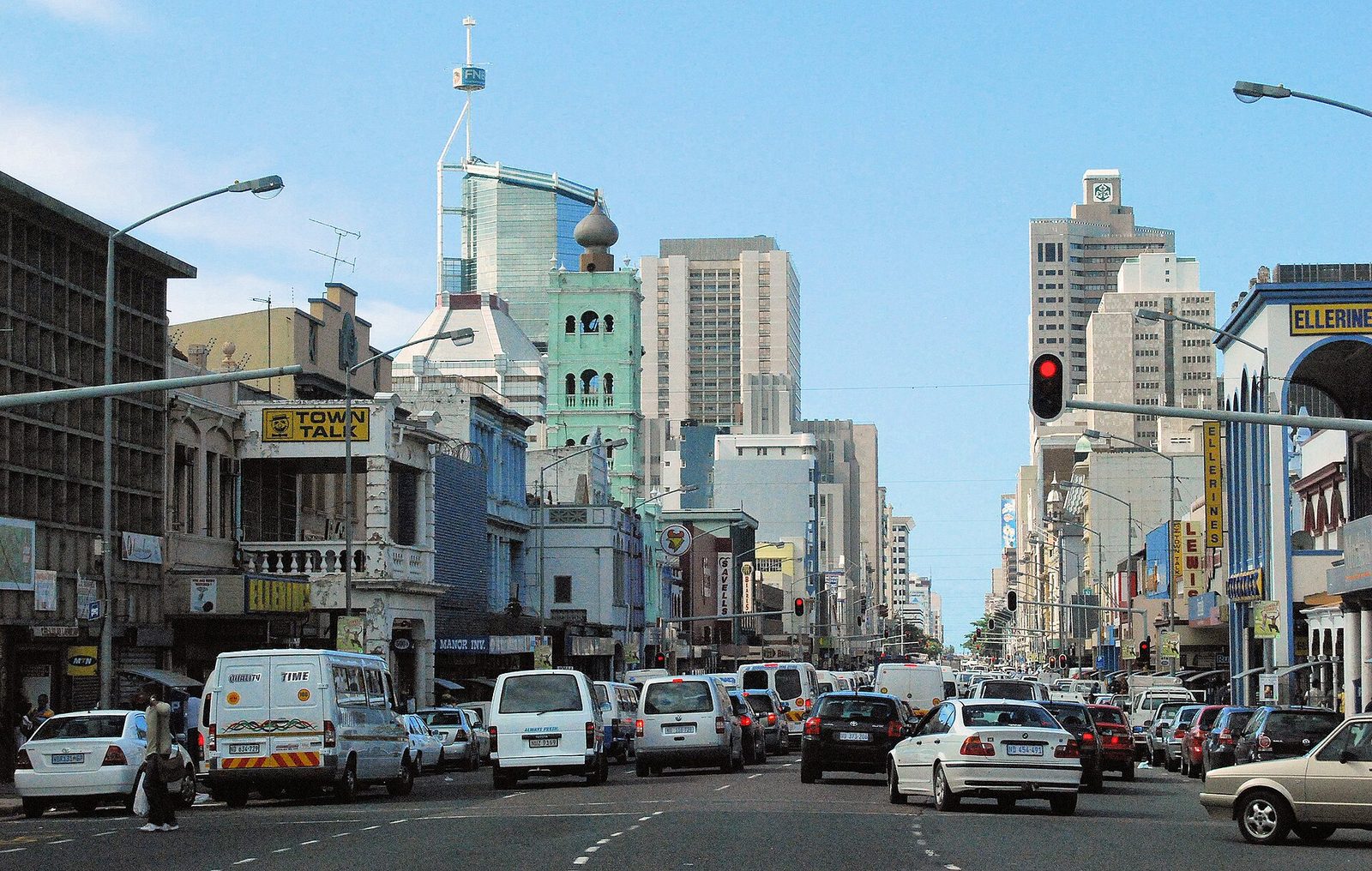 Wide view down busy city street with minibuses and tall buildings, Dr Pixley kaSeme Street