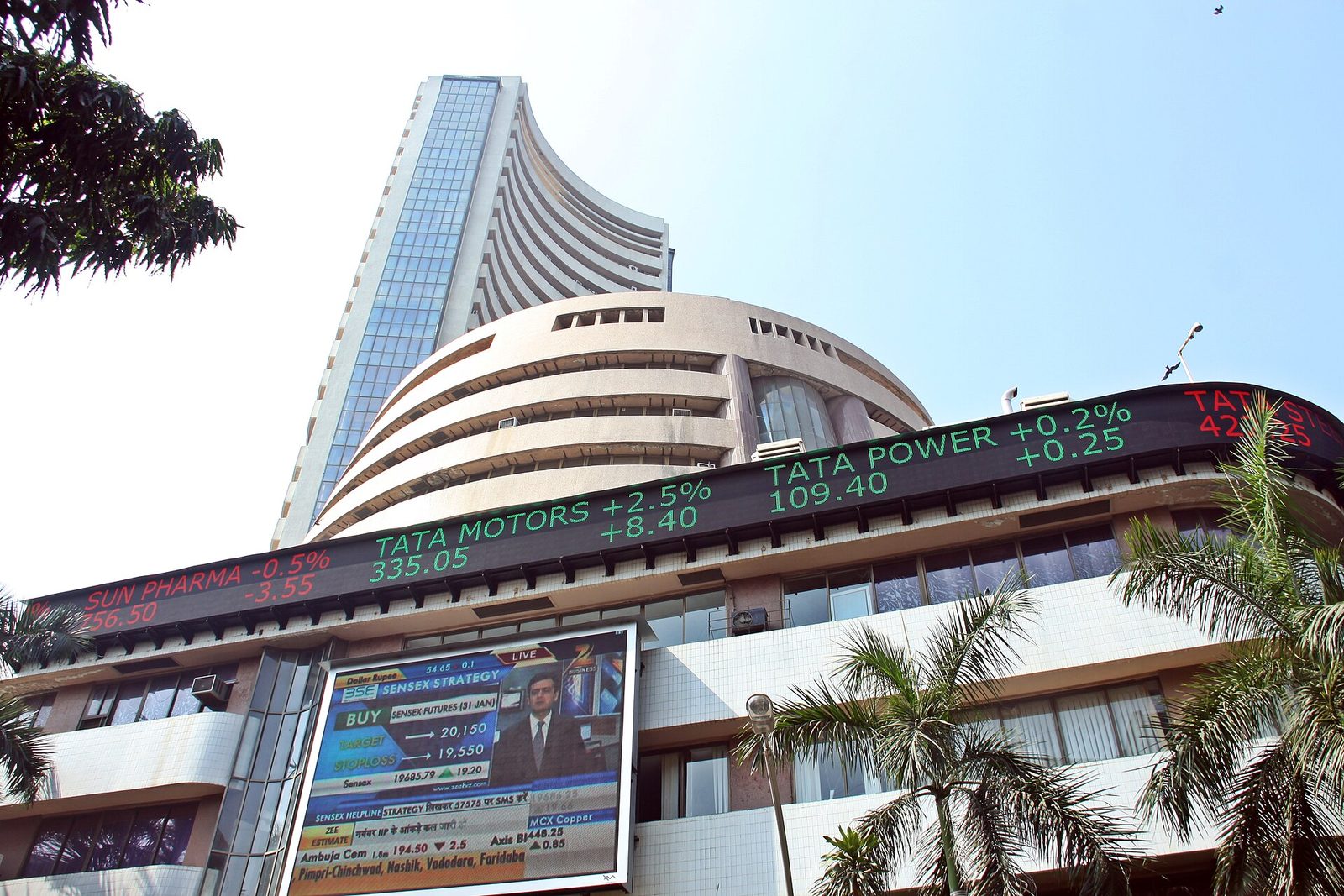 large curved stock exchange building, LED ticker showing stock prices, Mumbai