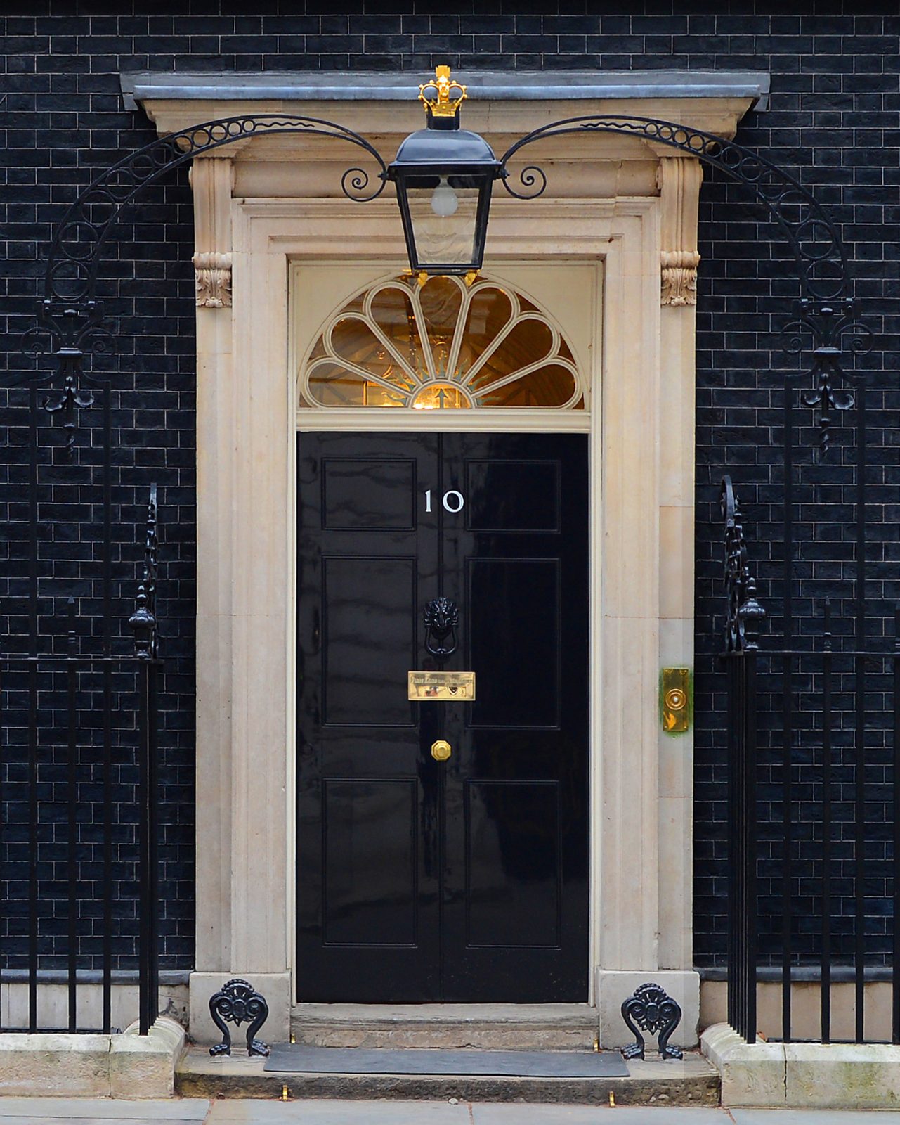 Black front door with number '10', stone surround and iron railings