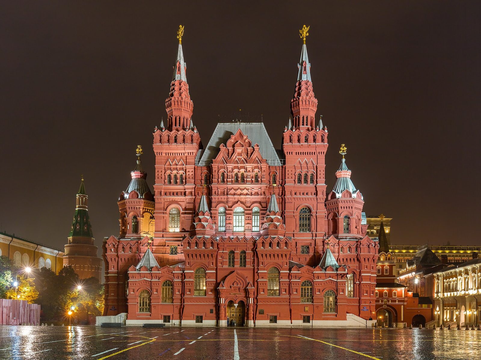 ornate red State Historical Museum building lit up at night, Moscow