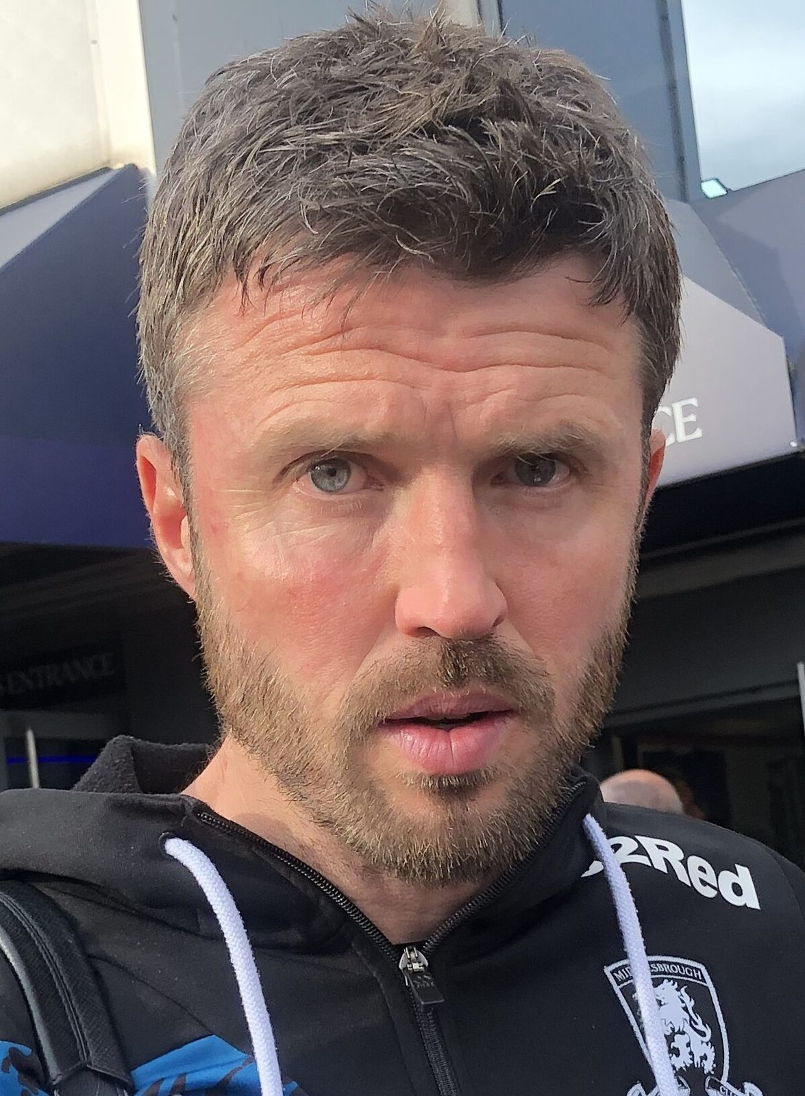 Close-up of a man with short beard, looking towards the camera