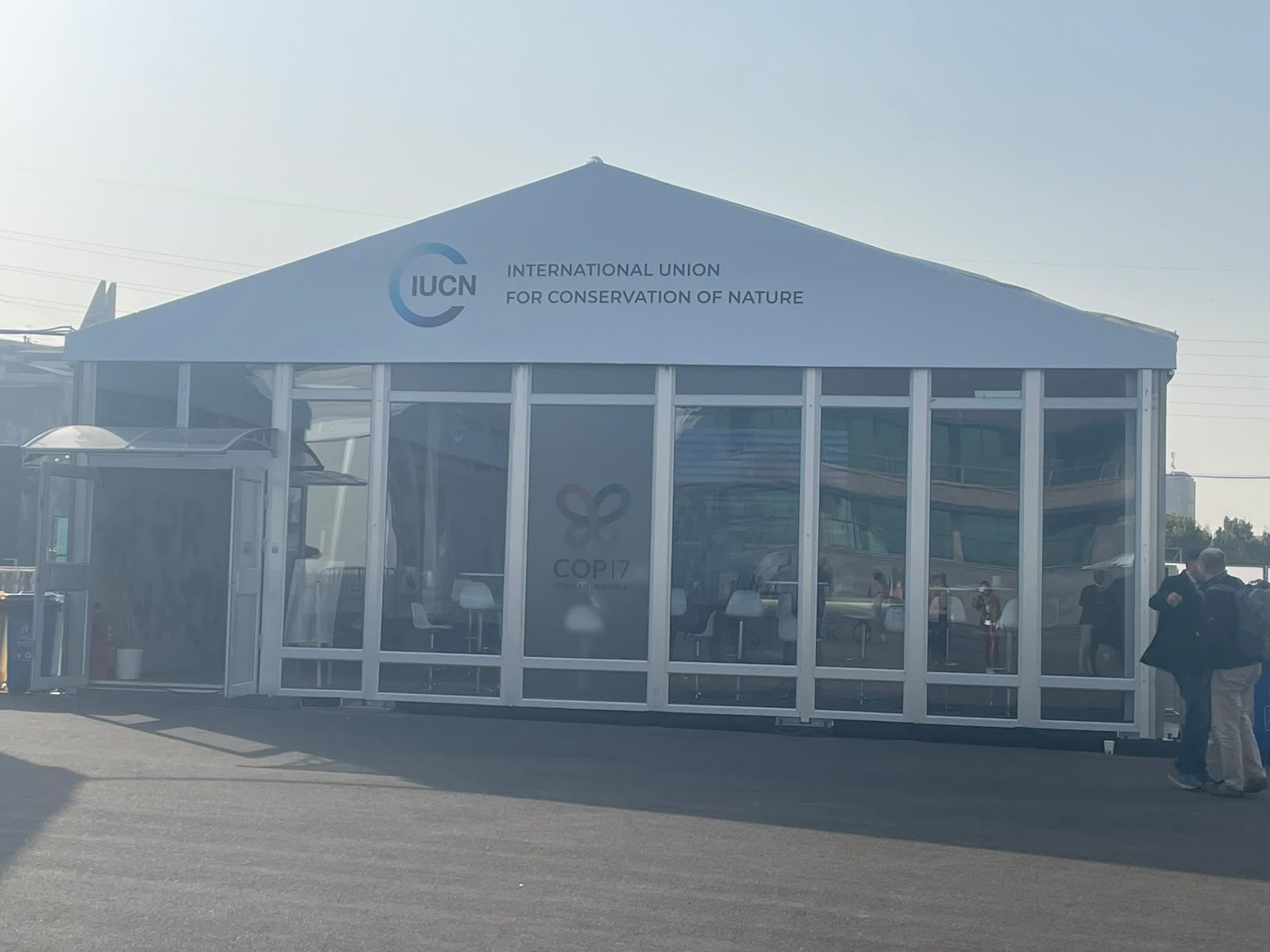 IUCN pavilion tent exterior with logo, COP17 reflections on windows, Yerevan