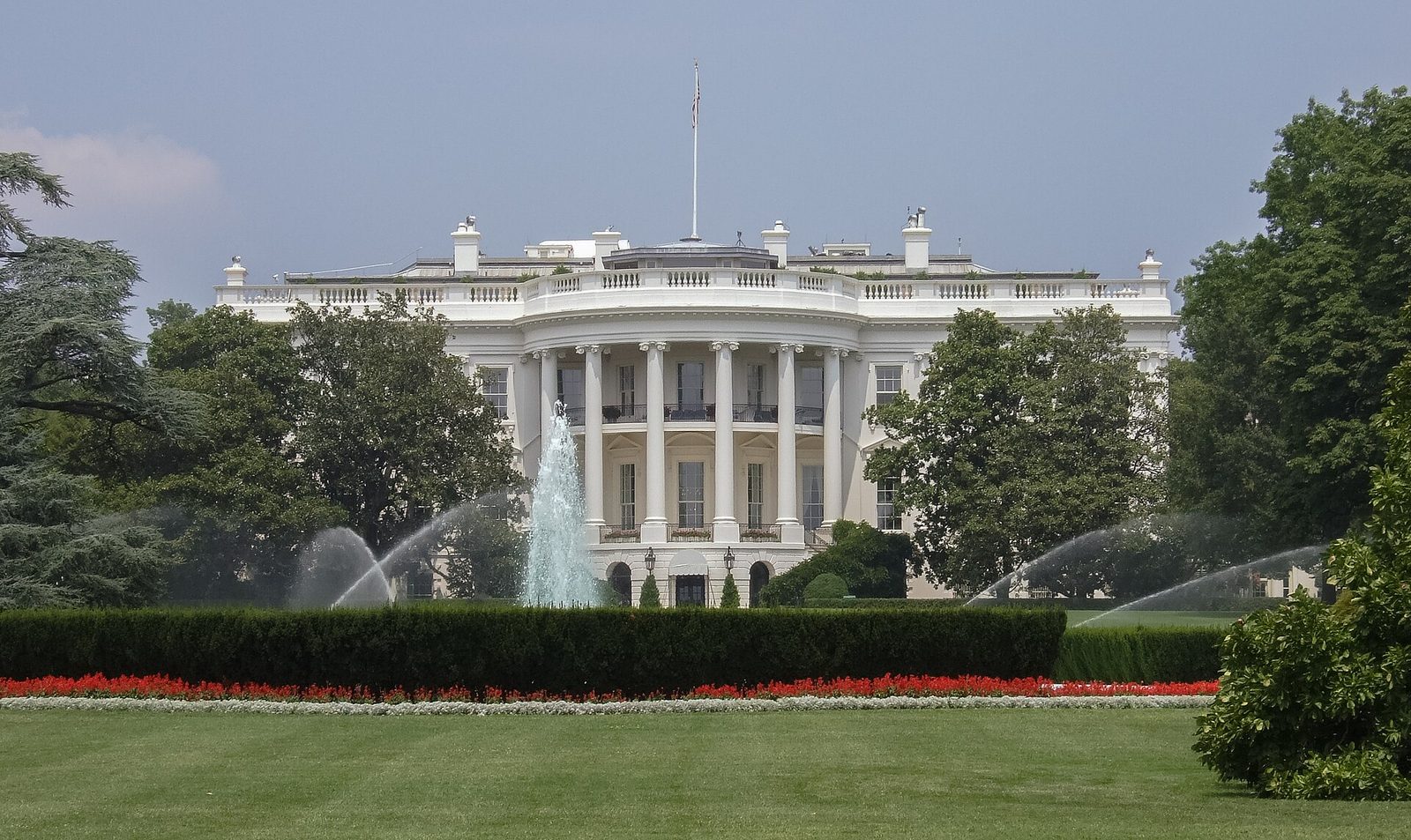 front of white neoclassical building, central columns, fountains and lawn, White House