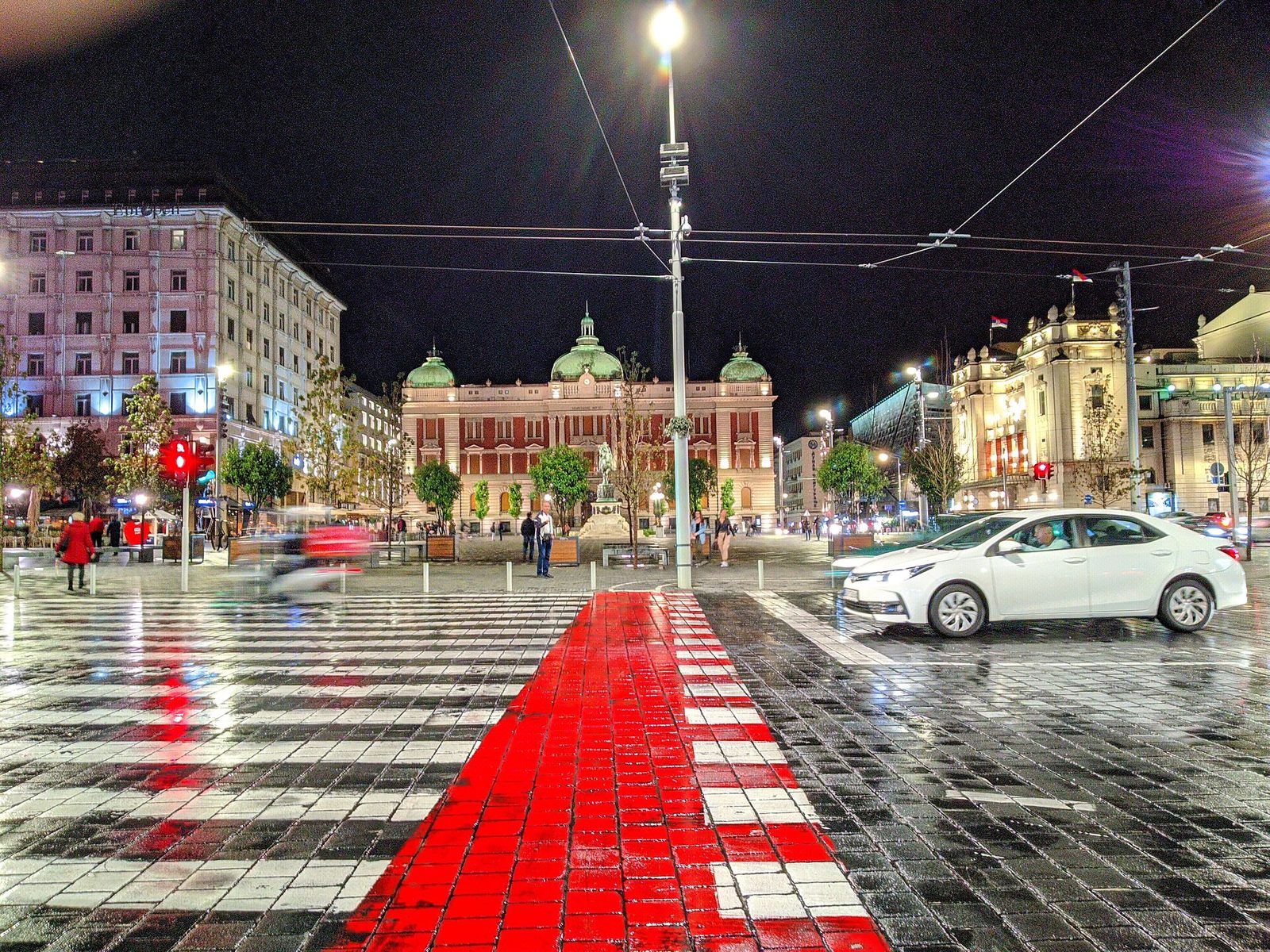 Night view of a city square with theatre building and wet reflective, Belgrade