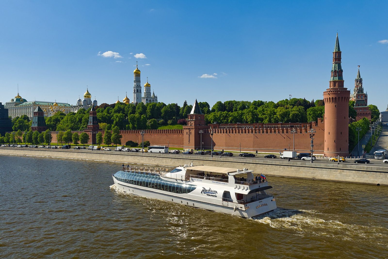 Daytime view of the Kremlin walls and cathedrals with river and boat, Moscow