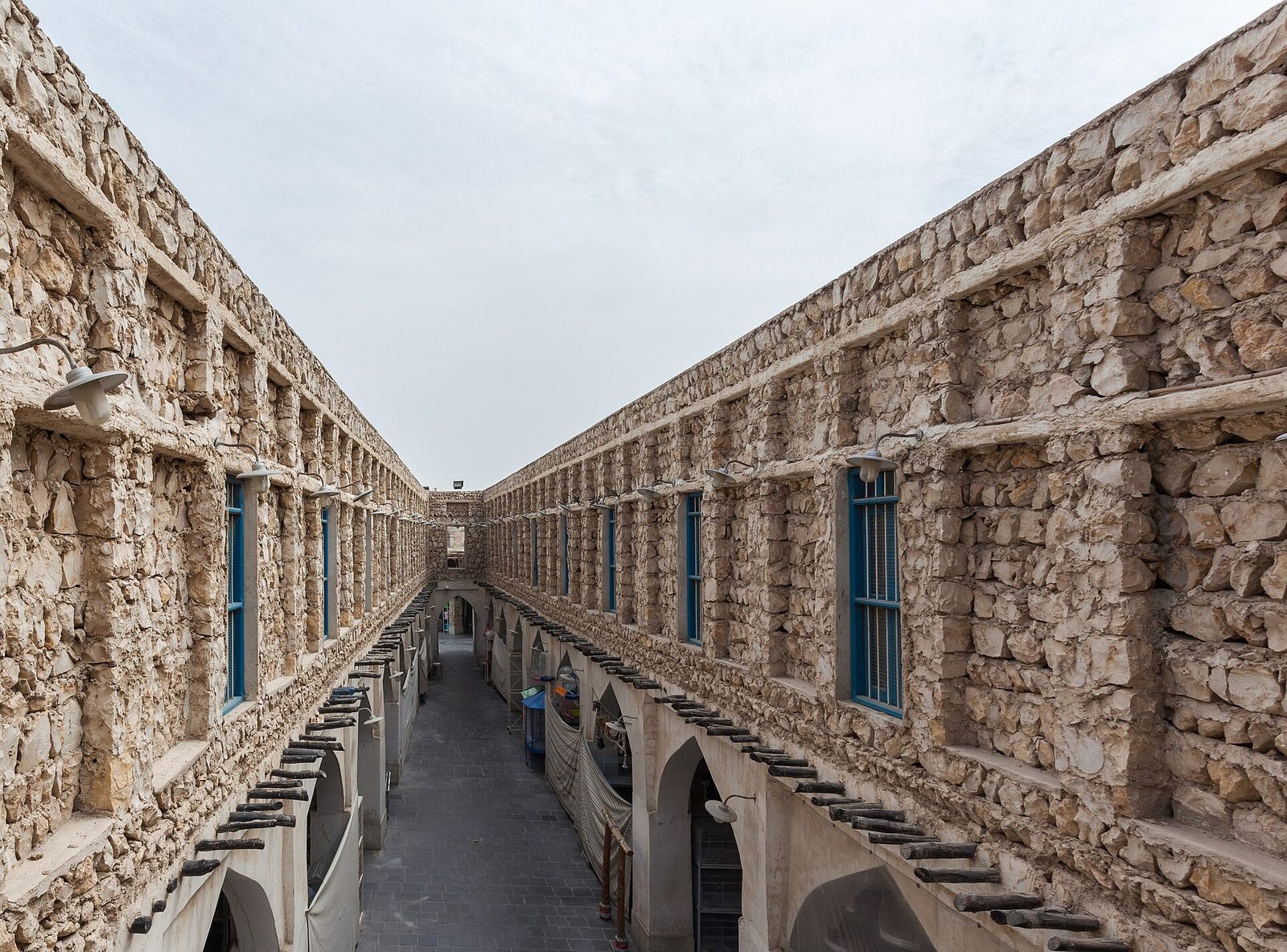 Narrow stone souq alley, two-storey arched shops and windows
