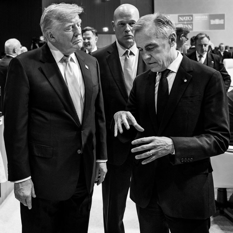 Two men talking in a conference room, one gesturing with hands