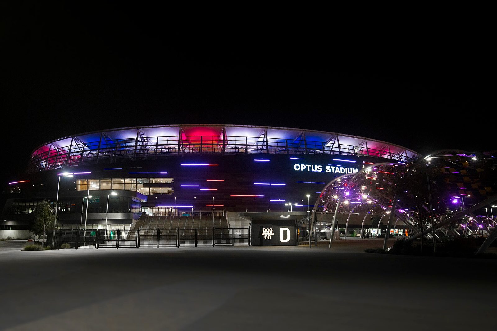 Illuminated stadium and lit pedestrian bridge seen at night, Perth