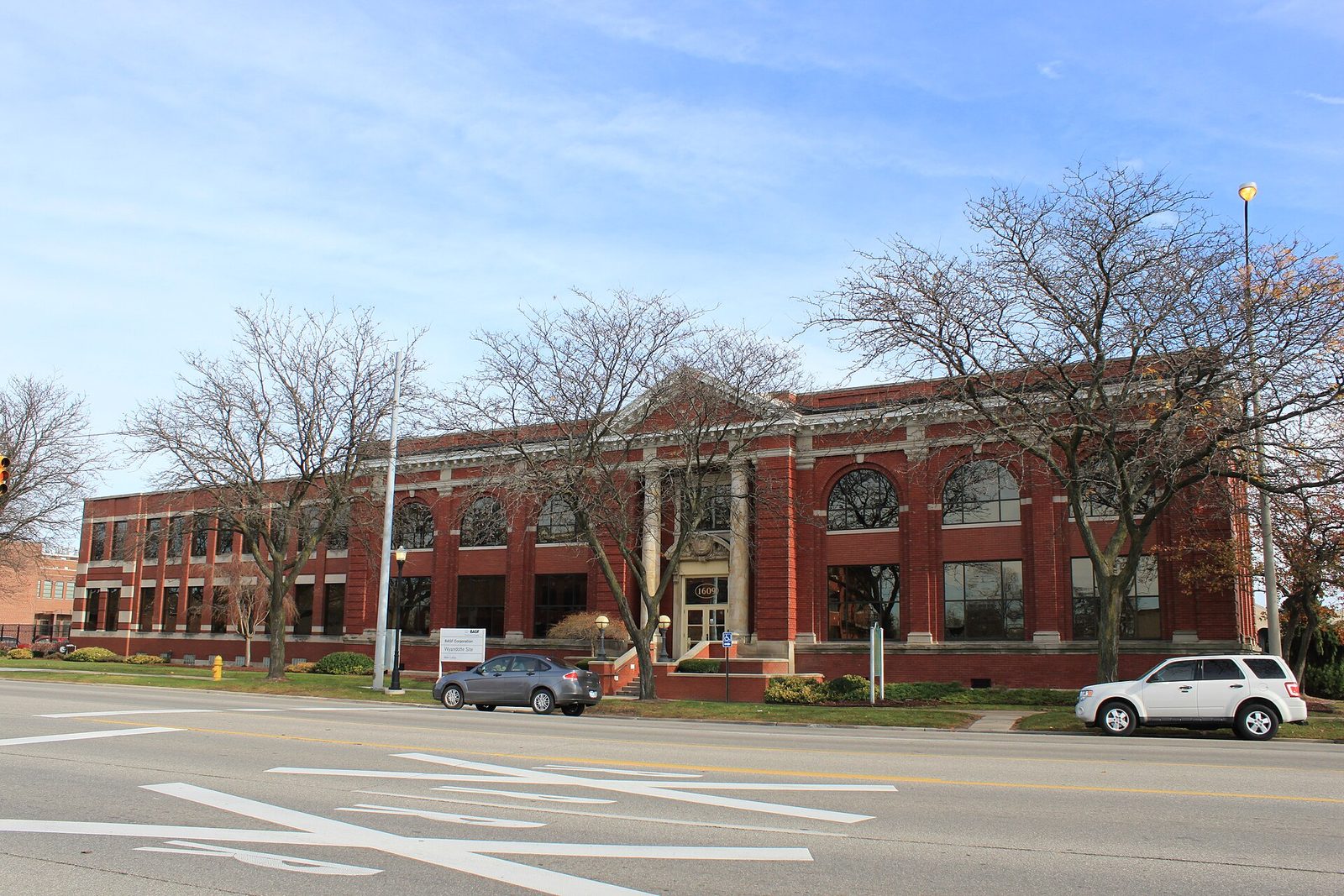 Red brick two storey historic office building facing a street, parked cars, Wyandotte