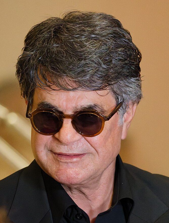 close portrait of a man wearing sunglasses and a dark suit