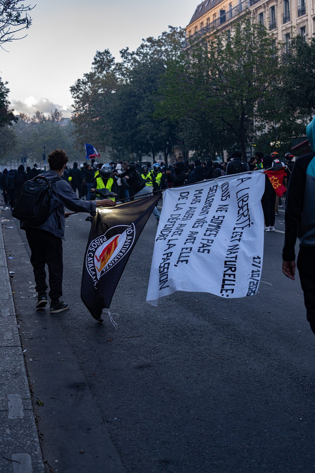 Protesters on a street, banners, smoke and a clustered crowd, Place de la République