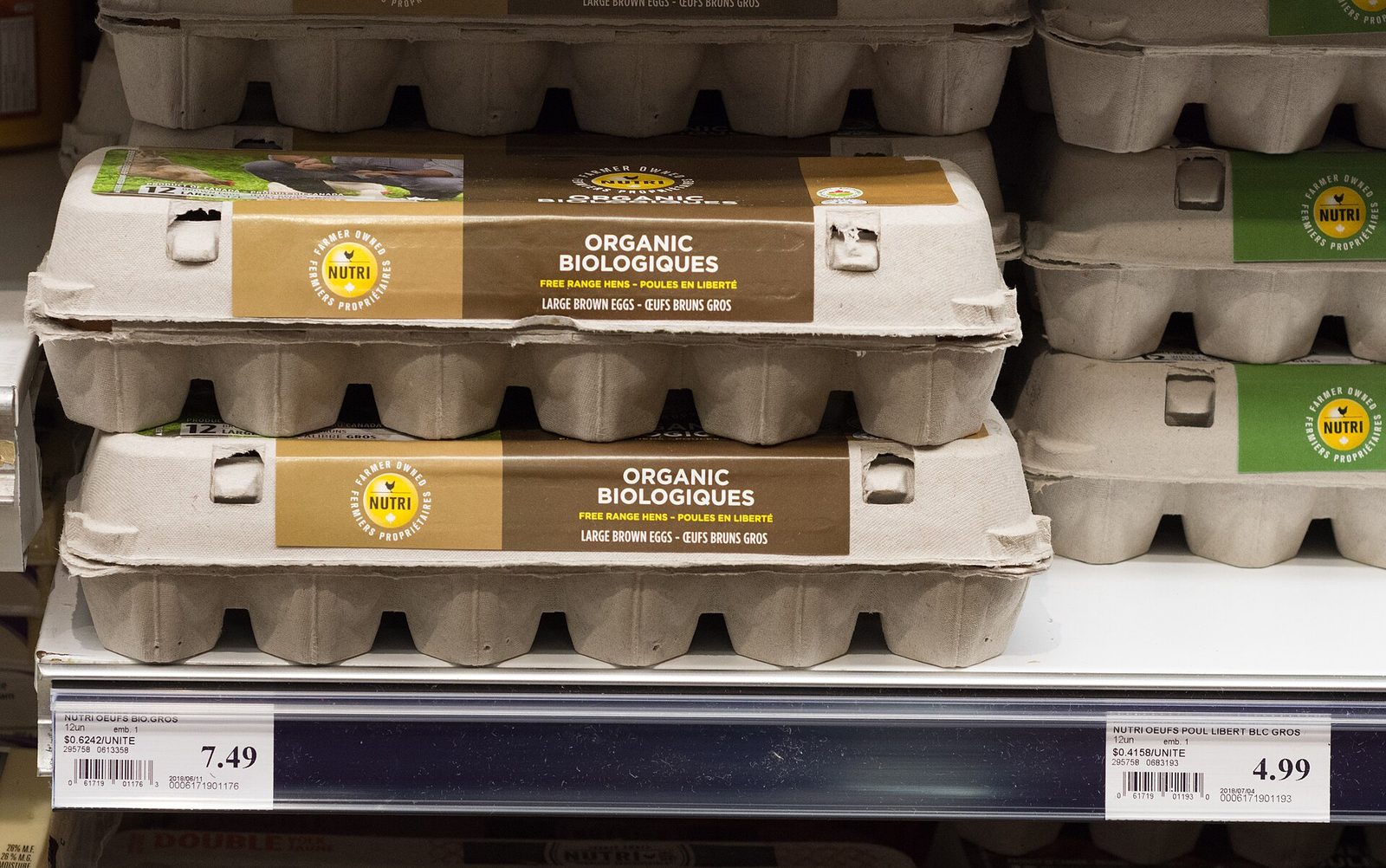 Stacked egg cartons on shelf with visible price labels