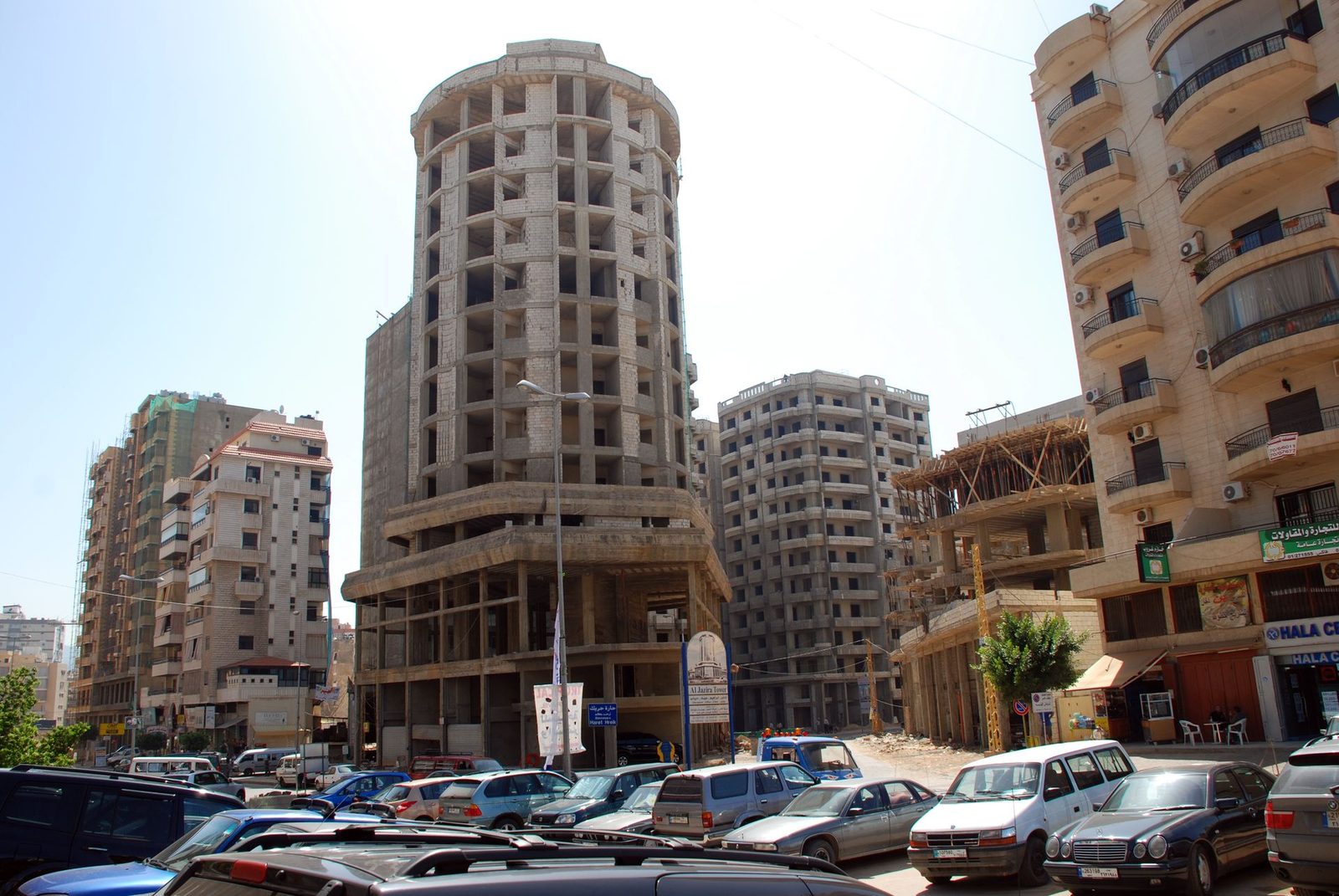 Partially constructed and older apartment blocks, urban street parking, Beirut
