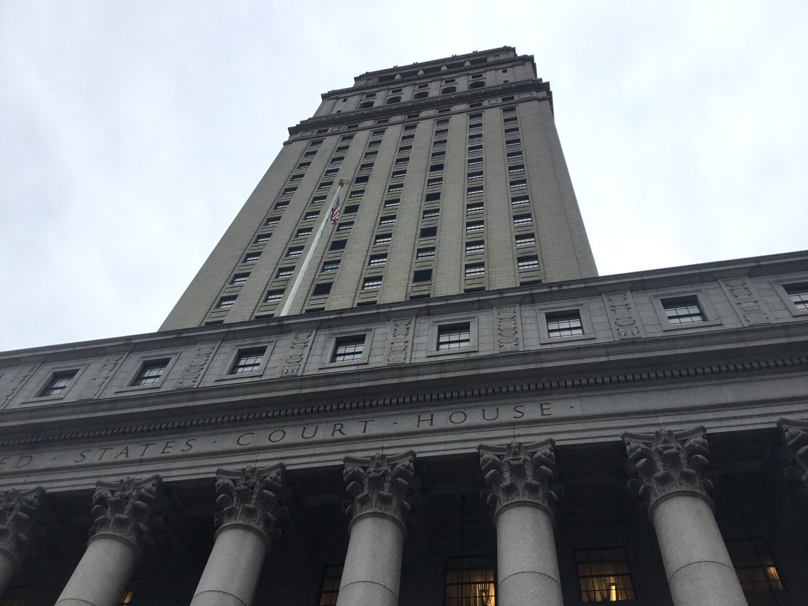 Low-angle view of courthouse facade, columns and flagpole, New York City