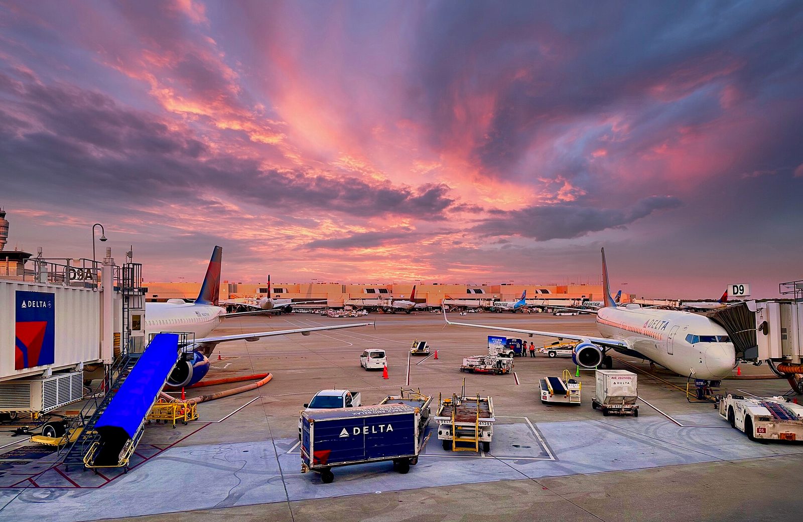 Delta aircraft at gates on apron, colourful sunset sky above, Atlanta