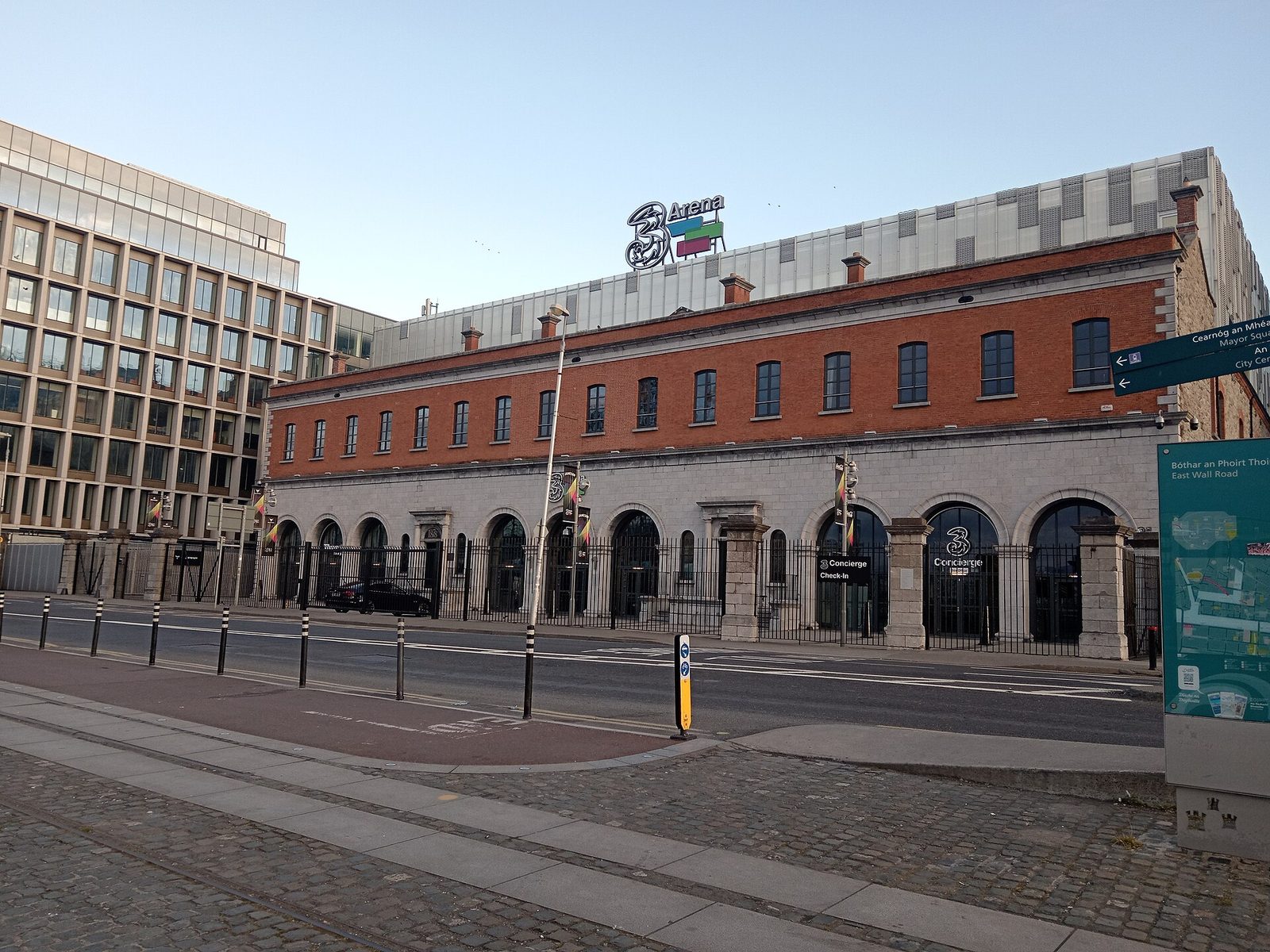 red brick and modern 3Arena building with signage, street and pavement in, 3Arena
