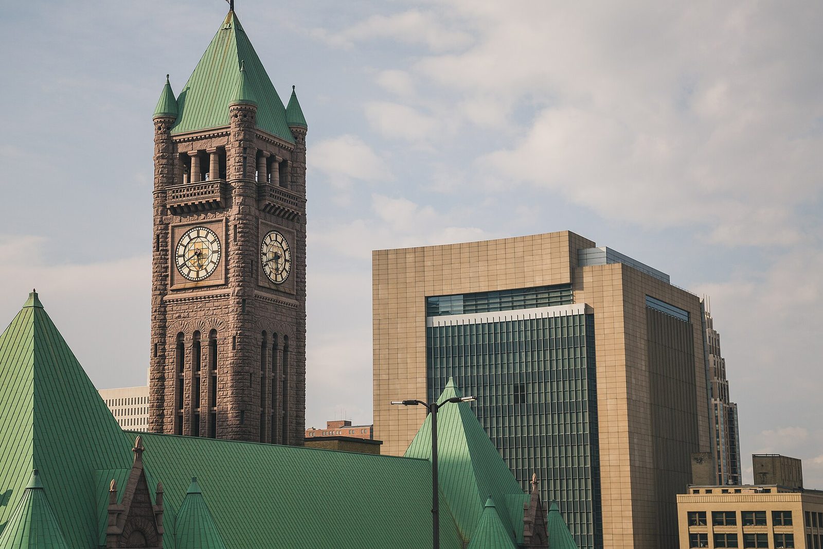 large clock tower and adjacent modern courthouse building under sky, Minneapolis